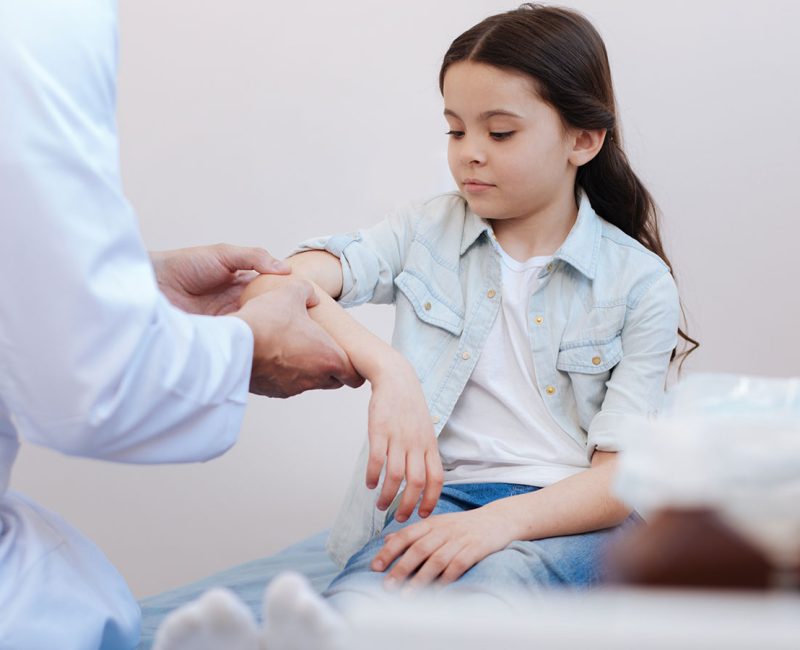 A child getting checked for an injury from a doctor.